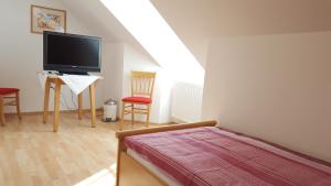 a bedroom with a bed and a flat screen tv at Gasthof Kremslehner in Stephanshart