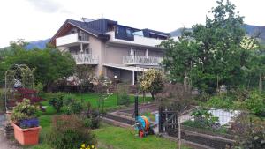 une maison avec un jardin en face dans l'établissement Ausserdorfer Apartments, à Lana