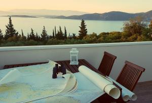 a table on a balcony with a view of the water at Captain's Attic in Račišće