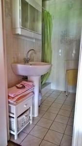 een badkamer met een witte wastafel en een tegelvloer bij A la source du saolon in Culmont