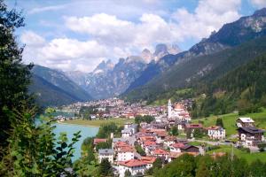 a town in a valley with a river and mountains at Hotel Aurora srls in Auronzo di Cadore