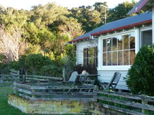 a house with two chairs and a porch at Hilltop Accommodation Catlins in Papatowai