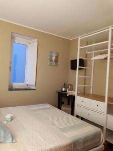 a bedroom with a bed and a desk and a window at B&B Sara e Angela in Salerno