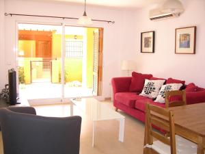 a living room with a red couch and a table at Albatros Playa 3 - 1307 in Mar de Cristal
