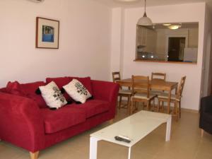 a living room with a red couch and a table at Albatros Playa 3 - 1307 in Mar de Cristal