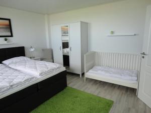 a bedroom with a white bed and a mirror at Fewo Am Deich mit Garten, 70m zum Strand, Fahrradgarage in Dahme