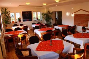 a restaurant with tables and chairs with red and white table cloth at Chatisko in Košická Belá