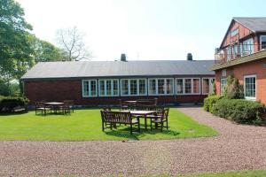 a building with tables and benches in front of it at Kongeåkroen in Brørup