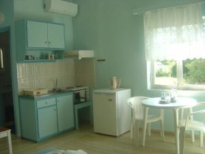 a kitchen with a table and a white table and a table and chairs at Roda Pearl Resort in Roda