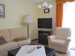 a living room with two chairs and a flat screen tv at Elisabeth Decker in Zeltingen-Rachtig