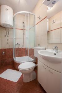 Un baño con inodoro, ducha y lavabo. en Apartments Klara, en Makarska