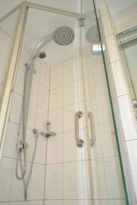 a shower in a bathroom with a glass door at Hotel Zum Lamm in Ansbach