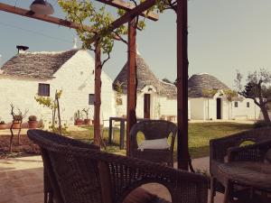 an outdoor patio with wicker chairs and a house at Lunalì in Alberobello