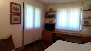 a room with a desk with a computer and two windows at Villa le Noci in Bettola