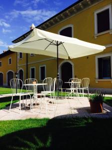 una mesa y sillas bajo una sombrilla blanca en Il Conte, en San Bonifacio