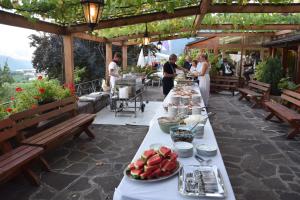 einen Tisch mit Teller mit Lebensmitteln auf einer Terrasse in der Unterkunft Hotel Tannhof in Kaltern