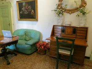 Casa Della Zia, Bologna by Short Holidays في بولونيا: غرفة معيشة مع أريكة ومكتب مع الكمبيوتر المحمول