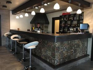 a bar with stools and a man in a mirror at Hotel-Restaurant Complex Relax in Zhytomyr