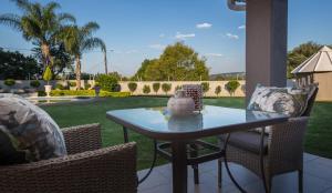 a table and chairs on a patio with a yard at La Vida Luka - Luxury Guesthouse in Pretoria