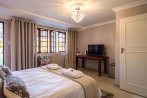 Pretoria的住宿－La Vida Luka - Luxury Guesthouse，一间卧室配有一张床、一张书桌和一个窗户。