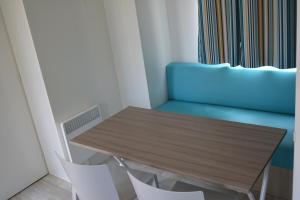 a dining room with a wooden table and white chairs at Camping Valencia el Saler in El Saler