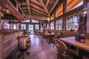 a restaurant with wooden tables and chairs and windows at Klampfererhof in Saalfelden am Steinernen Meer