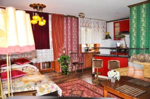 ヤロスラヴリにあるAppartment on Uglichskayaのリビングルーム(ベッド1台、テーブル付)、キッチンが備わります。