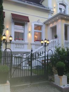 a white house with a black fence and lights at Berliner Hof in Dallgow