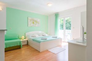 una camera da letto con un letto, un divano e una finestra di Apartments Nikolina a Hvar