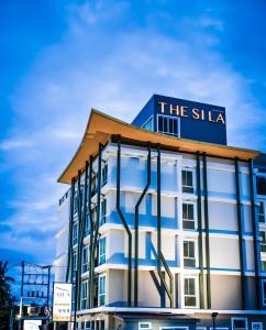 a building with a sign on the side of it at The Sila Hotel in Si Racha