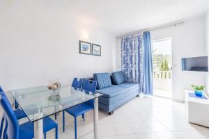 a living room with a blue couch and a glass table at Apartments Nikolina in Hvar