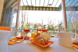 une table avec un pain sur une assiette dans l'établissement Hôtel Des Poètes avec parking sur réservation, à Béziers