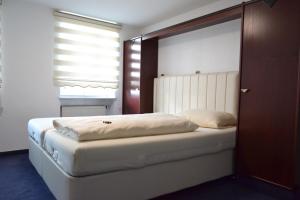 Schlafzimmer mit einem weißen Bett und einem Fenster in der Unterkunft Hotel Zum Lamm in Ansbach