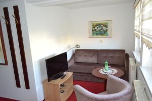 ein Wohnzimmer mit einem Sofa und einem Tisch in der Unterkunft Hotel Zum Lamm in Ansbach