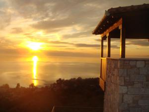 een zonsondergang over de oceaan vanuit een huis bij Karavia Lux Inn in Afissos