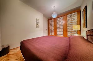 a bedroom with a bed and a large window at Apartments Popaj in Komiža