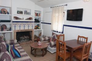 een woonkamer met een tafel en een open haard bij Ca L'Isabel in Villanueva de los Castillejos