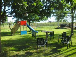 una mesa y sillas en un parque con un tobogán en Agriturismo Le Gazze, en Camposanto