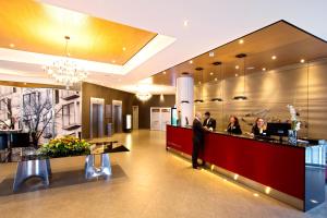 a man standing at a counter in a hotel lobby at Abba Berlin Hotel in Berlin