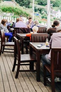 a group of people sitting at tables in a restaurant at Ship Inn in Aberporth