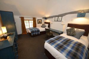 a hotel room with two beds and a desk at The White Lion Inn in Hampton in Arden