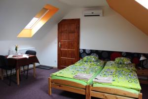 a bedroom with a green bed and a table at Dj-penzion in Vracov