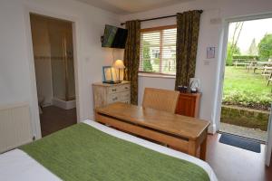 1 dormitorio con cama, escritorio y ventana en The White Lion Inn, en Hampton in Arden