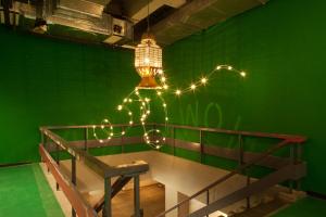 a chandelier with lights hanging from a green wall at WOW Amsterdam Hostel in Amsterdam
