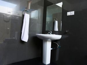 a bathroom with a sink and a mirror at Pasikudah Eco Village Hotel in Pasikuda
