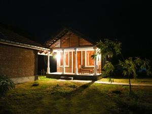 a house with a light on the front of it at night at Pasikudah Eco Village Hotel in Pasikuda