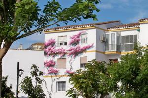 a white building with pink flowers on it at Apartamentos Miguel Angel in Estepona
