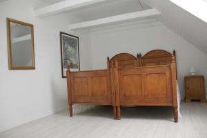 a bedroom with a wooden bed and a mirror at Apartment 4 in Tønder