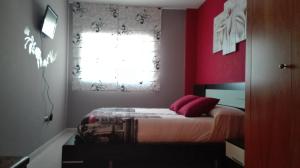 サロウにあるrosa sensatのベッドルーム1室(赤い壁のベッド1台、窓付)