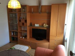 een woonkamer met een tv en een boekenplank bij Austernfischer Fewo I in Borkum